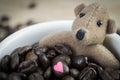 Little brown bear and coffee beans in white mug Royalty Free Stock Photo