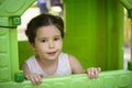 Little brown hair girl smiling through the window of kids playhouse Royalty Free Stock Photo