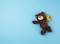 Little brown teddy bear holds in his paw a yellow ribbon folded in a loop Royalty Free Stock Photo