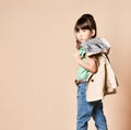 The little brunette is standing with her back turned and wearing a beige raincoat. Royalty Free Stock Photo