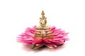 a little Buddha statue sitting on a pink lotus flower isolated on white background Royalty Free Stock Photo