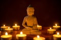 Little buddha statue surrounded by tea candles Royalty Free Stock Photo