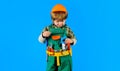 Little builder boy in helmet and toolbelt playing with toy saw. Child game. Cute kid in protective hard hat with tool Royalty Free Stock Photo