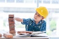 Builder boy is learning how to build brick wall