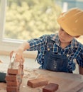 Little Builder boy learning how to build brick wall in vintage tone
