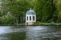 a little building next to a lake in the park