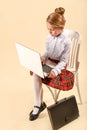 Little business girl write in notepad. Business style clothing, plaid skirt, white blouse. Work at the laptop. Emotional child, Royalty Free Stock Photo