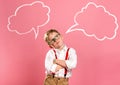 Schoolboy in glasses near blue wall with text cloud with space for your text. Thinking kid. Dream big. Back to school Royalty Free Stock Photo