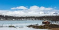 Little cabin in the wilderness towards icy lake Royalty Free Stock Photo