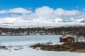 Little cabin in the wilderness towards icy lake and snow Royalty Free Stock Photo