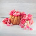 Little cake, pie on wooden white kitchen plate with spring flowers tulips and roses Royalty Free Stock Photo