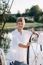 a little captain at the helm on a yacht. a little boy at the helm of the captain on a yacht at sunset