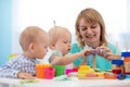 Little caucasian baby playing with Montessori toy in pre-school