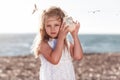 Little caucasian blond girl holding seashell and listening Royalty Free Stock Photo