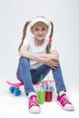 Little Caucasian Blond Girl in Visor Sitting on Pink Pennyboard Royalty Free Stock Photo