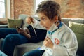 Little caucasian boy as a doctor consulting for patient, working in cabinet, close up