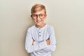 Little caucasian boy kid wearing casual clothes and glasses happy face smiling with crossed arms looking at the camera Royalty Free Stock Photo