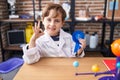 Little caucasian boy at school scientist laboratory winning first prize doing ok sign with fingers, smiling friendly gesturing