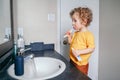 Little Caucasian boy toddler brushing teeth in bathroom at home. Health hygiene and morning routine for children. Cute funny child Royalty Free Stock Photo