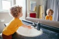 Little Caucasian boy toddler washing hands in bathroom at home. Health hygiene and morning routine for children. Cute funny child Royalty Free Stock Photo