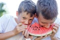 Little caucasian children eating watermelon