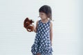 A little Caucasian frown girl holding brown bear doll and looking at her teddy bear Royalty Free Stock Photo