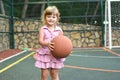 Little caucasian girl with ball on outdoor playground. children`s sports for health. Royalty Free Stock Photo