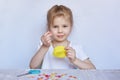Little Caucasian girl child learns to sew colorful buttons. Royalty Free Stock Photo