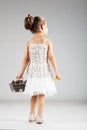 Little caucasian girl holding cart with pinecones