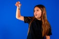 Little caucasian girl holding an hourglass over blue estudio background Royalty Free Stock Photo