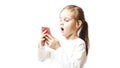 Little caucasian girl holding a smartphone in her hands and is greatly amazed looking at it
