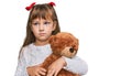 Little caucasian girl kid hugging teddy bear stuffed animal thinking attitude and sober expression looking self confident Royalty Free Stock Photo