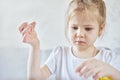 Little Caucasian girl learns to sew with a needle. Royalty Free Stock Photo