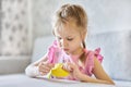 A little Caucasian girl learns to sew with a needle and thread. Royalty Free Stock Photo