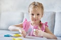 A little Caucasian girl learns to sew with a needle and thread. Royalty Free Stock Photo