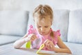 A little Caucasian girl learns to sew with a needle and thread. Royalty Free Stock Photo