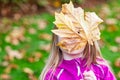 Little caucasian girl with blond hair holding a big yellow leaf Royalty Free Stock Photo