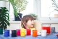 Little caucasian girl paints small toy figures in home interior. A cute three year old child is engaged in creativity Royalty Free Stock Photo