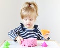 Little Caucasian Girl Playing with Pink Kinetic Sand at Home