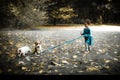 Little caucasian girl running around the autumn park with the dogs. Royalty Free Stock Photo