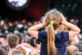 Little Caucasian girl on father`s shoulders watching the concert in the crowd
