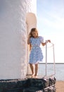 little Caucasian girl in a white dress and long hair, walking to the sea. Royalty Free Stock Photo