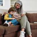 Caucasian granddaughter playing on digital tablet next to grandmother Royalty Free Stock Photo