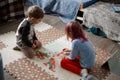 Little caucasian kids playing a board game on the floor in their room Royalty Free Stock Photo