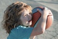 Little caucasian sports kid playing basketball holding ball with funny face.