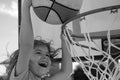 Little caucasian sports kid playing basketball holding ball with happy face. Funny excited child face.