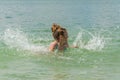 Little charming girl child bathes in a lake and plays splashing water Royalty Free Stock Photo