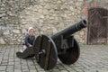 Little charming girl child at the historic ancient cannon in the old castle of the fortress