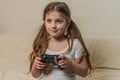 Little charming girl child plays a joystick in a video game on a game console Royalty Free Stock Photo