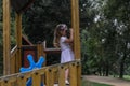 Little charming girl playing on the playground in the park, looking through toy binoculars Royalty Free Stock Photo